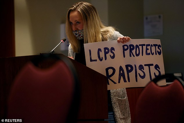 Amanda Shallant (pictured) spoke during a school board meeting last week as she held a sign that read: 'LCPS protects rapists'