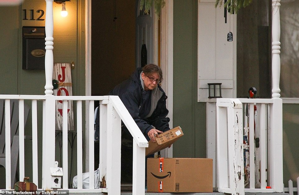 A neighbor of the Crumbleys is pictured picking up packages and taking them in for them on Thursday