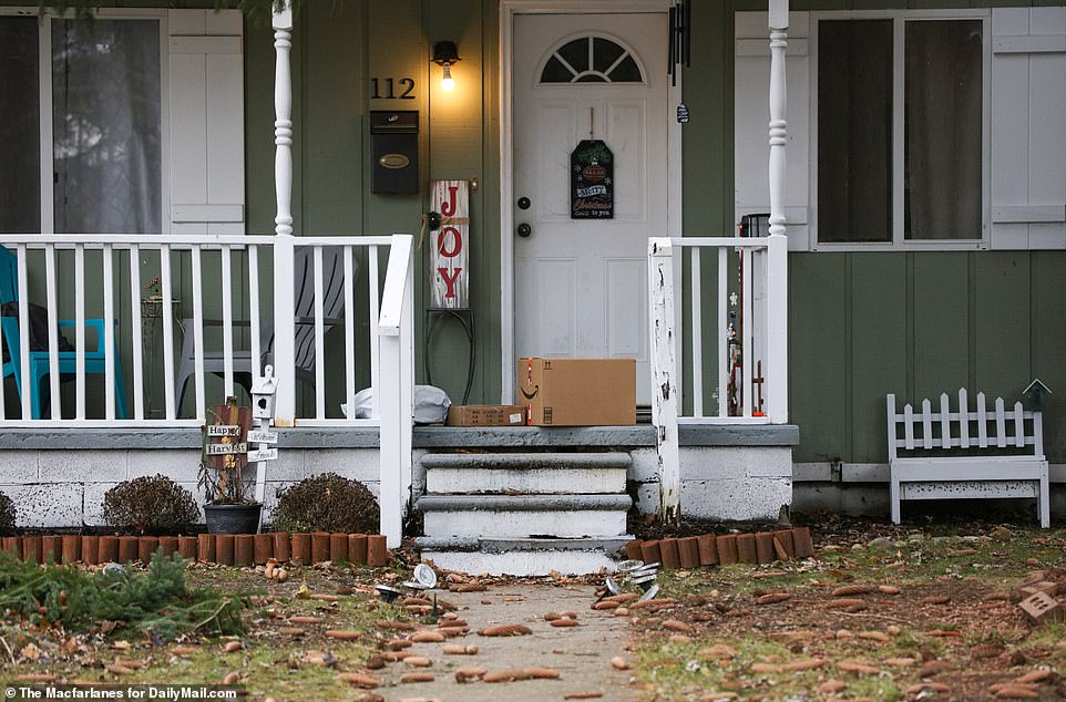 On Thursday, a holiday sign reads 'Joy' and packages are piled on the porch at the Crumbley family's home. Police say Jennifer and James Crumbley are on the run