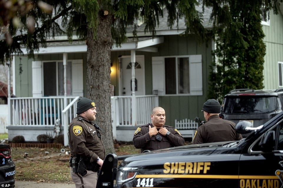 Three Oakland County Sheriff's deputies survey the grounds outside of the Crumbley residence while seeking James and Jennifer Crumbley, parents of alleged Oxford High School shooter Ethan Crumbley, on Friday
